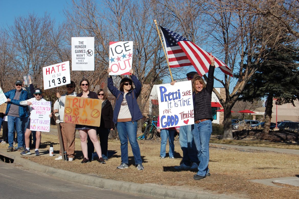 Protestors on the side of a busy street.